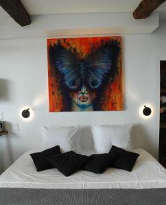 1 dormitorio con 1 cama con una pintura de mariposa en la pared en L'essens, en Fayence