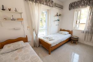ポロスにあるRigos House at Askeli beach, Poros islandのベッドルーム1室(ベッド2台、窓付)