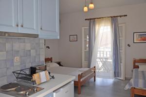 a kitchen and living room with a bed and a table at Nostos Studios in Aegiali
