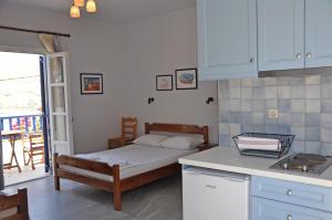 a small kitchen with a bed in a room at Nostos Studios in Aegiali