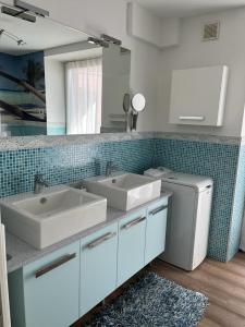 ein Badezimmer mit 2 Waschbecken und einer Waschmaschine in der Unterkunft CA' del GIACOMINO in Baselga di Pinè