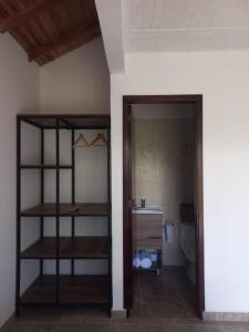 Habitación con baño con aseo y estante. en Villa Paulina en Guadalupe