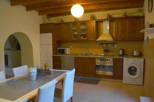 a kitchen with wooden cabinets and a table with chairs at Casa Benavista in Kerásia