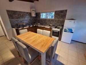 a kitchen with a wooden table and a refrigerator at El Remanso in Villa Residencial Laguna Brava