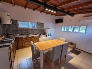 a kitchen with a wooden table and chairs at El Remanso in Villa Residencial Laguna Brava