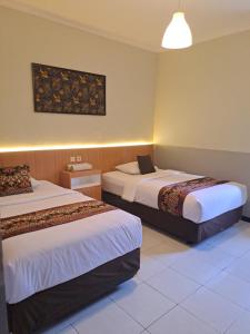 una habitación de hotel con 2 camas en una habitación en WISMA ANUGERAH HOMESTAY, en Bonorejo