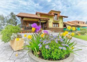 una casa con flores delante en La Aguilerina Apartamentos Rurales en Oviñana