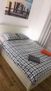 a bed with a blue and white checkered comforter at Apartament Baltic Sea - Gdańsk Zaspa in Gdańsk