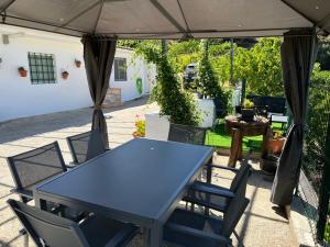 a blue table and chairs under an umbrella at Cortijo Mazarrón in Güéjar-Sierra