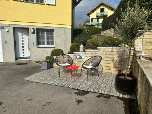 twee stoelen en een rode kruk zittend in een tuin bij V&A Home 