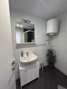 a white bathroom with a sink and a mirror at Little Shine in Bol
