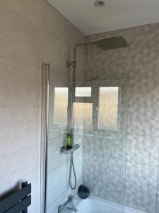 a bathroom with a shower with a tub and a sink at Gants hill in Barkingside