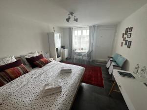 Habitación blanca con cama y escritorio en V&A Home 