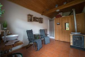 a bathroom with a tub and a table and chairs at Ferienwohnung Hoffmann - Eifel in Nimshuscheid