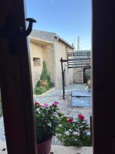 an open door to a courtyard with flowers and a bench at Casa Benavista in Kerásia
