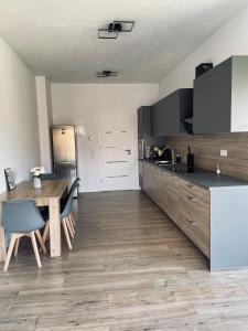 eine Küche mit einem Holztisch und Holzböden in der Unterkunft Apartmány 400 in Veľká Lomnica