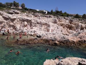 a group of people swimming in a body of water at Peri peri room in Siracusa