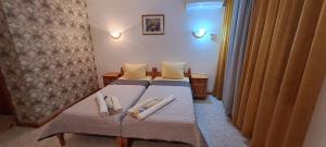 zwei Betten in einem Hotelzimmer mit Handtüchern darauf in der Unterkunft Hotel Gamartata in Duni + 83 Fotos
