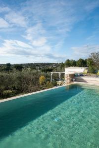 ein Pool mit blauem Wasser in einem Haus in der Unterkunft Lacinera Trulli e Lamie in Ostuni