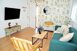 Una sala de estar con un sofá azul y un televisor. en Terraza privada MarDeLunas, en El Bosque