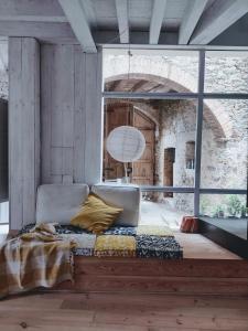 a bedroom with a bed and a large window at CAN TANDO Restored catalan old barn to enjoy peaceful rural simplicity in Sant Jordi Desvalls