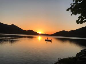 twee mensen in een boot op een meer bij zonsondergang bij Hotel Seerose in Fuschl am See