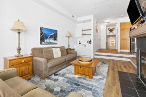 ein Wohnzimmer mit einem Sofa und einem Kamin in der Unterkunft Blue Mountain Ski In Ski Out Resort Condo 2 Level in Blue Mountains