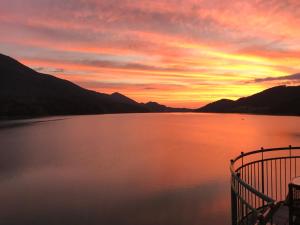 a sunset over a body of water with mountains at Hotel Seerose in Fuschl am See