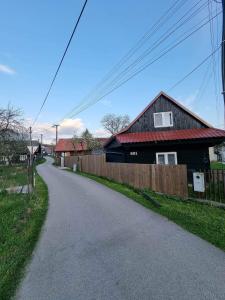 una casa al lado de una carretera con una valla en Drevenica na Považí, en Dolná Mariková