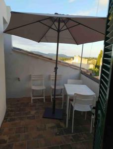 un tavolo e sedie con ombrellone su un balcone di ANTIC ESTANC a Campanet