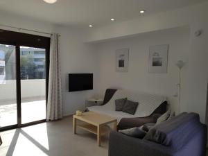 ein Wohnzimmer mit einem Sofa und einem TV in der Unterkunft Sea Breeze Apartment in Ixia
