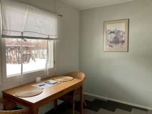 a dining room table with two chairs and a window at Huoneistomajoitus Pirtti, LaatuLomat in Juva