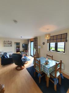 a living room with a table and a couch at Self catering accommodation three bedroom house or one bedroom cottage in Tomintoul