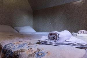 a bed with towels sitting on top of it at Kućice Paradiso in Bratunac