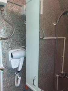 a shower stall with a blow dryer and a shower at Kućice Paradiso in Bratunac