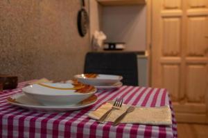 una mesa con platos de comida en un mantel rojo y blanco en Kućice Paradiso en Bratunac