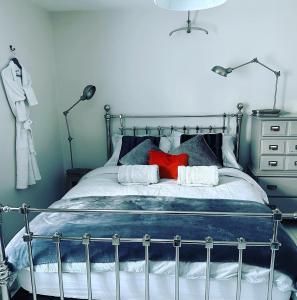 a bedroom with a bed with a red pillow at Spa Cottage Weymouth in Weymouth