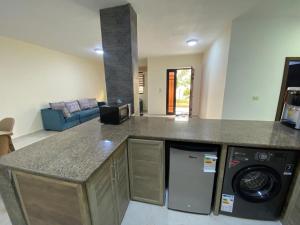 a kitchen with a counter top and a living room at Moon Apartments in Jerash