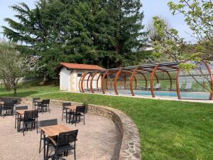 un grupo de mesas y sillas junto a una piscina en Villa Harriet, en Uhart-Cize