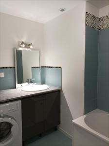 a bathroom with a sink and a washing machine at Plein centre, T3, 2ch, balcon et vue in Mèze