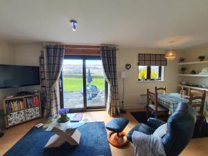 a living room with a couch and a table at Self catering accommodation three bedroom house or one bedroom cottage in Tomintoul