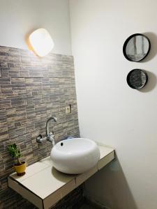 a bathroom with a white sink and a light at Keur Madior in Ngaparou