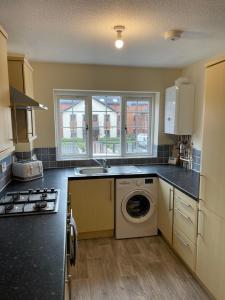 una cocina con lavadora y secadora. en Spacious 8 bed house in central Grimsby en Grimsby