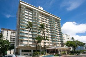 un edificio alto con palmeras delante en soulfactory Hawaii, en Honolulu