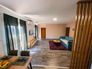 Apartman KOSTA في تريبينيي: غرفة معيشة مع أريكة زرقاء وطاولة