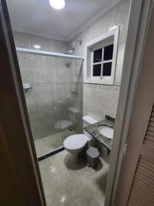 uma casa de banho com um chuveiro, um WC e um lavatório. em Pousada Catedral em Petrópolis