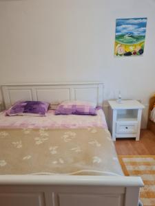 a bedroom with a bed and a table with a picture on the wall at Apartment Bataja in Brkač