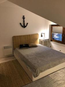 1 dormitorio con 1 cama con ancla en la pared en Apartament Premium Łeba en Żarnowska