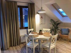 a dining room with a white table and chairs at Apartament Premium Łeba in Żarnowska