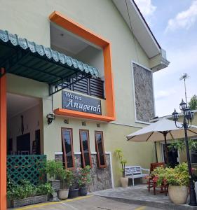 un edificio con un letrero para un restaurante con patio en WISMA ANUGERAH HOMESTAY, en Bonorejo